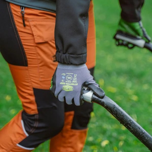 Solidur GAT01 grip gloves with safety stretch material - being worn by a forestry worker using a wheelbarrow - Lifestyle Product Image